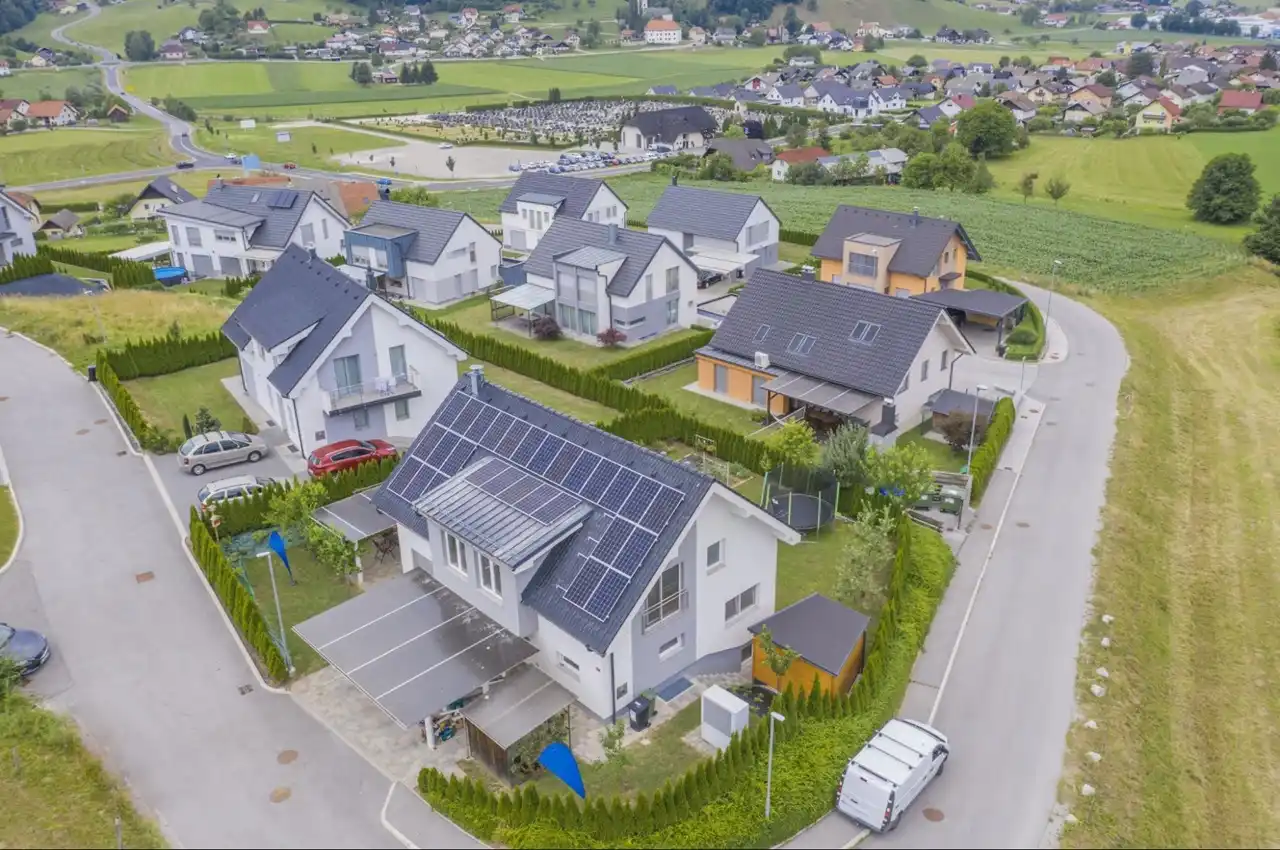 Vista aérea de várias casas com painéis solares instalados em telhados.