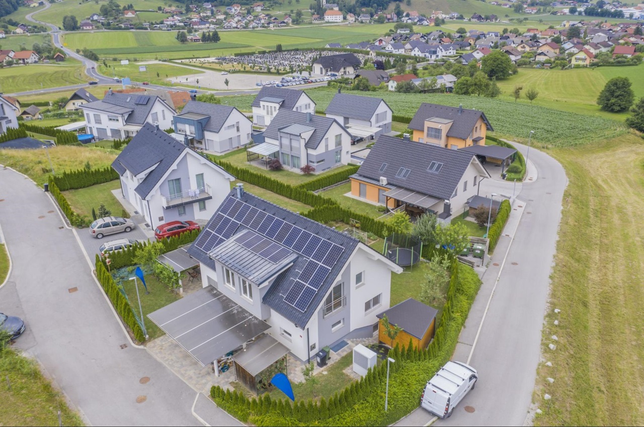 Vista aérea de várias casas com painéis solares instalados em telhados.