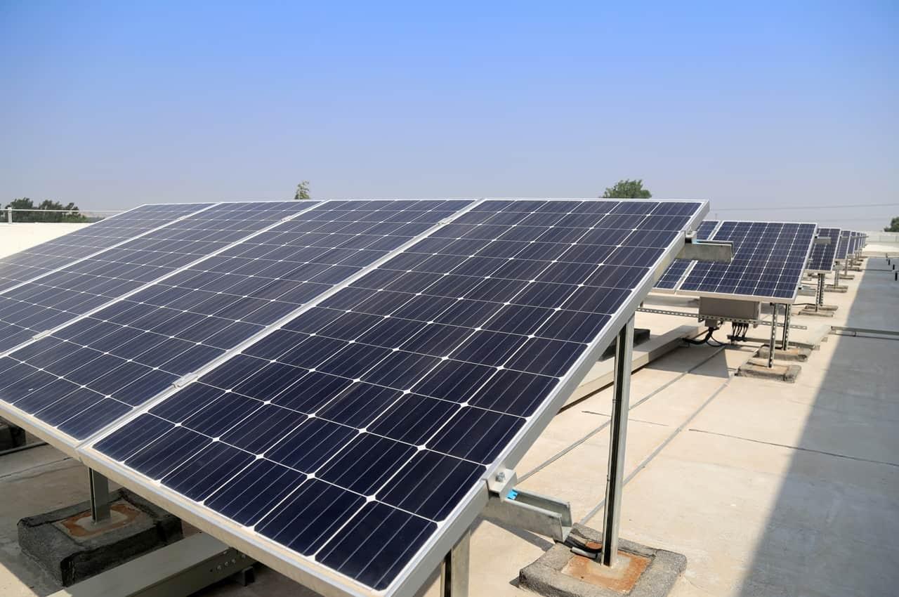 Painéis solares instalados em um telhado sob céu claro, em uma instalação de energia solar residencial.