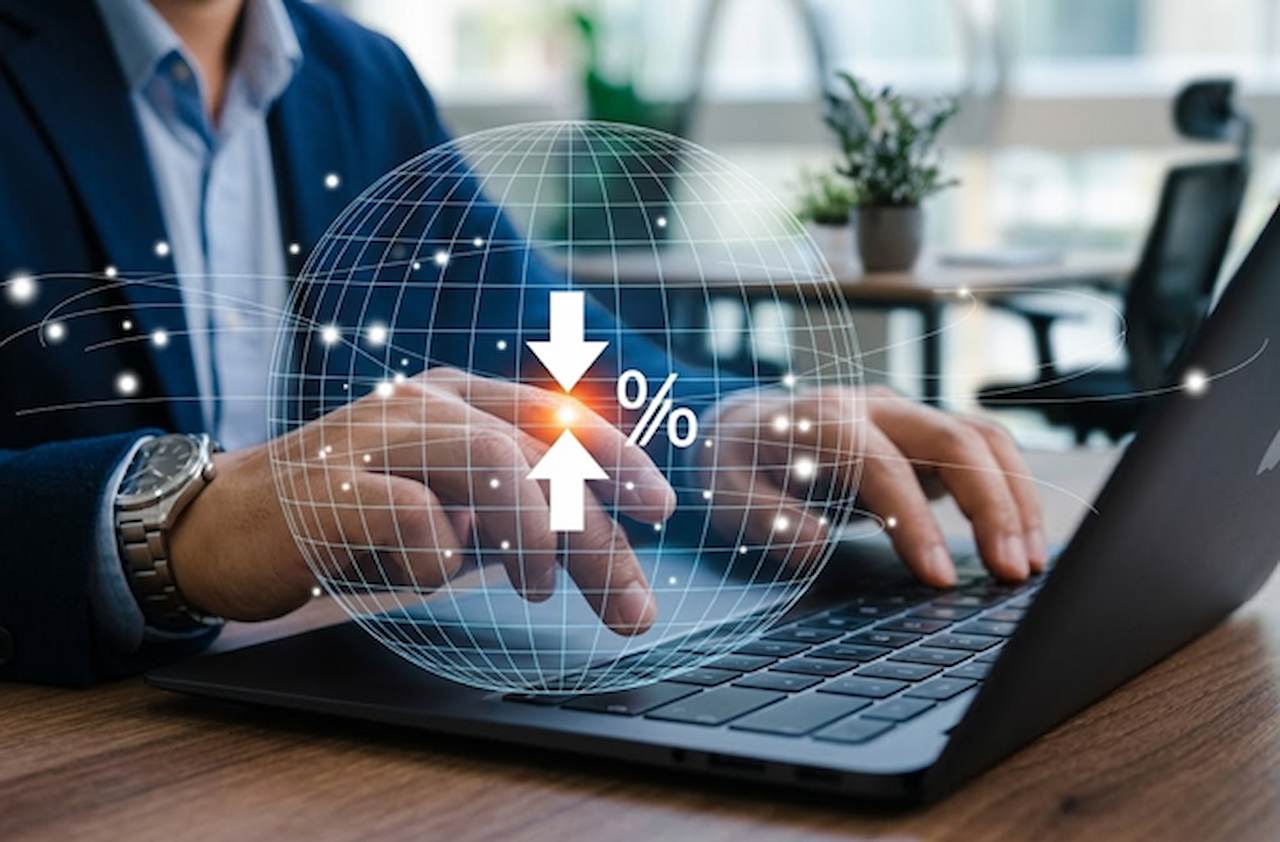 Homem de terno digitando no laptop, com uma esfera de grade digital, setas de convergência e ícone de porcentagem se sobressaindo.