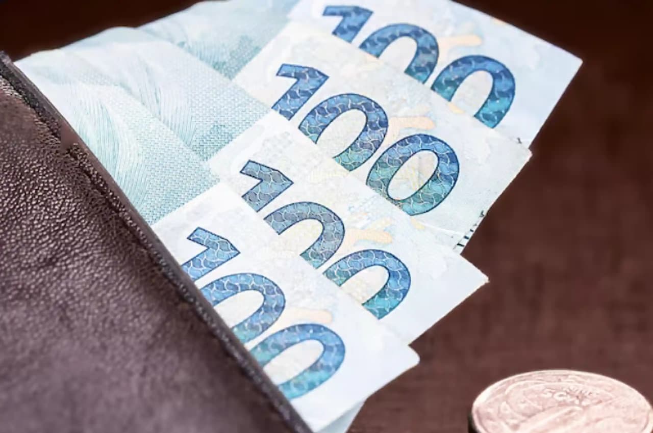 A imagem mostra um homem desfocado em traje social utilizando uma caneta digital para traçar um gráfico de crescimento.