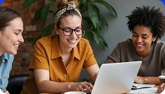 Colaboradores trabalhando juntos em frente a um laptop em ambiente de escritório moderno.