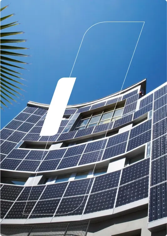 Um prédio com placas solares instaladas na fachada, em um dia de céu azul, sem nuvens.