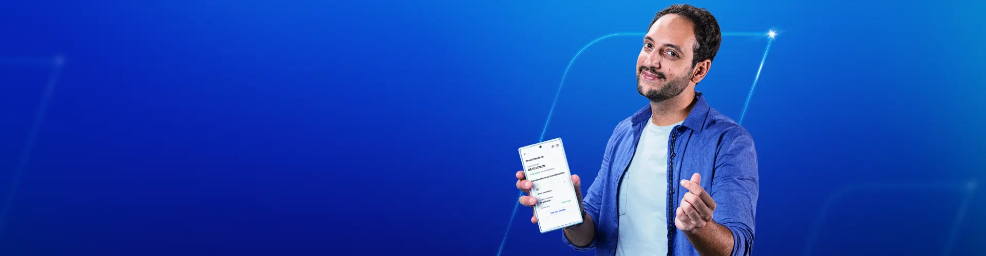 Imagem com fundo azul, com um homem branco, sorrindo. Na mão direita, ele faz um sinal e na esquerda segura um celular.