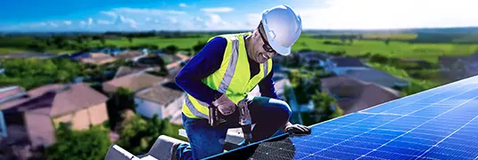 Homem sorrindo enquanto trabalha em placa solar.