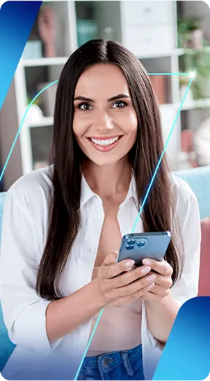 Uma mulher sorrindo enquanto segura um celular com as duas mãos.