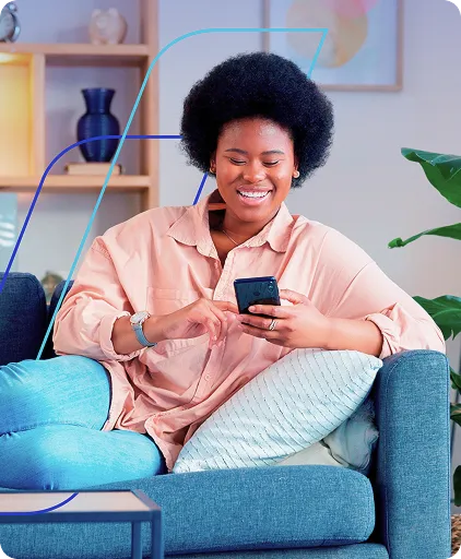 Mulher sentada em sofá utilizando o celular