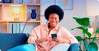 Mulher sentada em sofá utilizando o celular