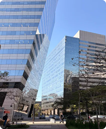 Dois prédios espelhados refletem o céu azul.