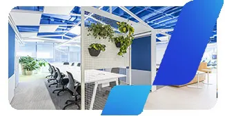 Escritório do banco BV com mesa coletiva e decoração com plantas