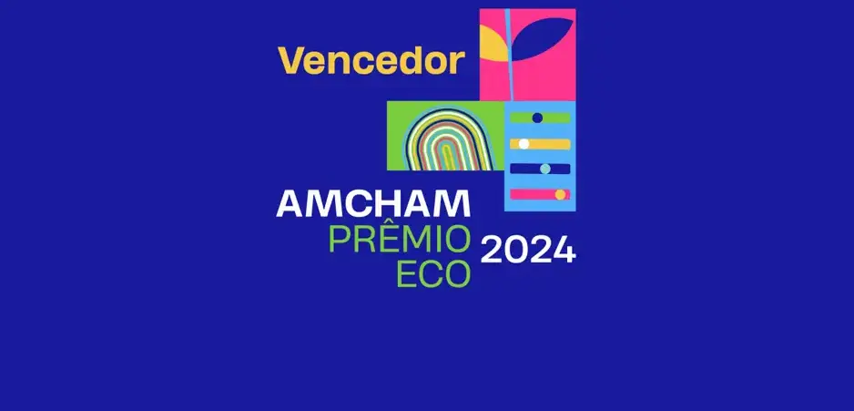 Símbolo colorido do 'AMCHAM Prêmio ECO 2024' com a palavra 'Vencedor' em destaque sobre fundo azul.