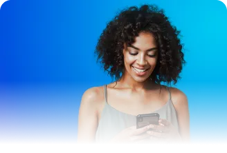 Uma mulher negra de cabelos cacheados na altura no queixo, segura o celular com as duas mãos e sorri.