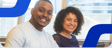 Um homem e uma mulher sentados um ao lado do outro sorrindo, com elementos visuais azuis sobrepostos à imagem. 