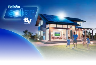Uma casa com placas solares no telhado e uma família de dois adultos e duas crianças brincando com uma bola.