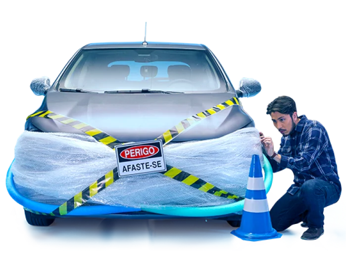 Um carro interditado embalado com plástico, um cone de risco e um homem abaixado ao lado do carro