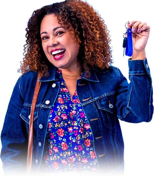 Mulher em pé, muito feliz, com uma chave de carro na mão