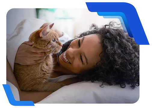 Pessoa deitada acaricia um gato laranja sobre a cama, em momento de convivência e cuidado.