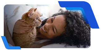 Pessoa deitada acaricia um gato laranja sobre a cama, em momento de convivência e cuidado.