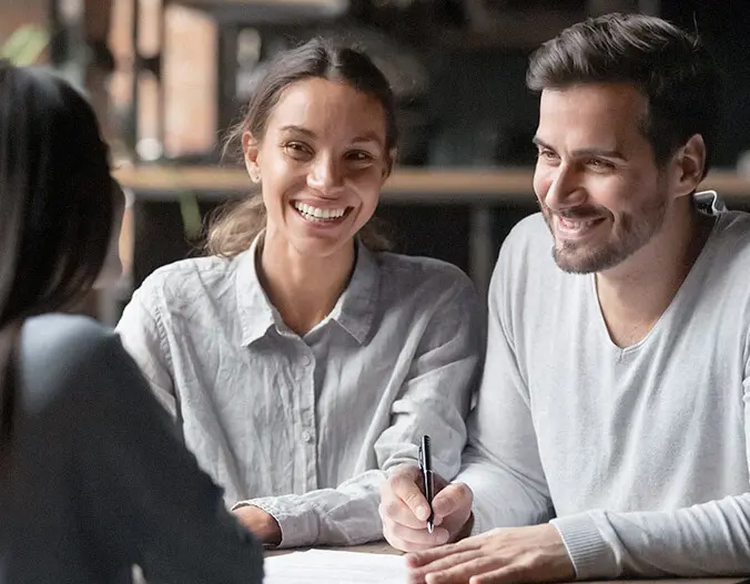 Um homem e duas mulheres conversando em uma mesa