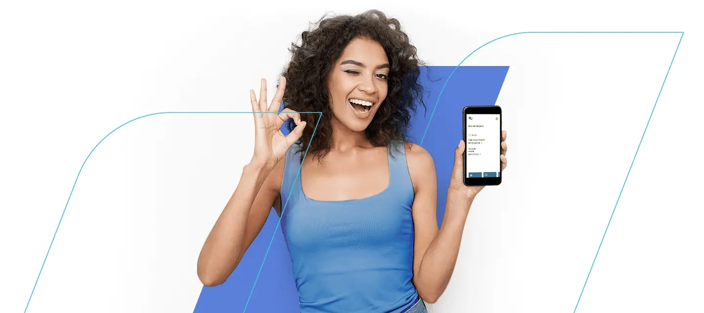Na imagem vemos uma mulher negra, ela está vestindo azul e está com um dos braços levantados, onde segura um celular.