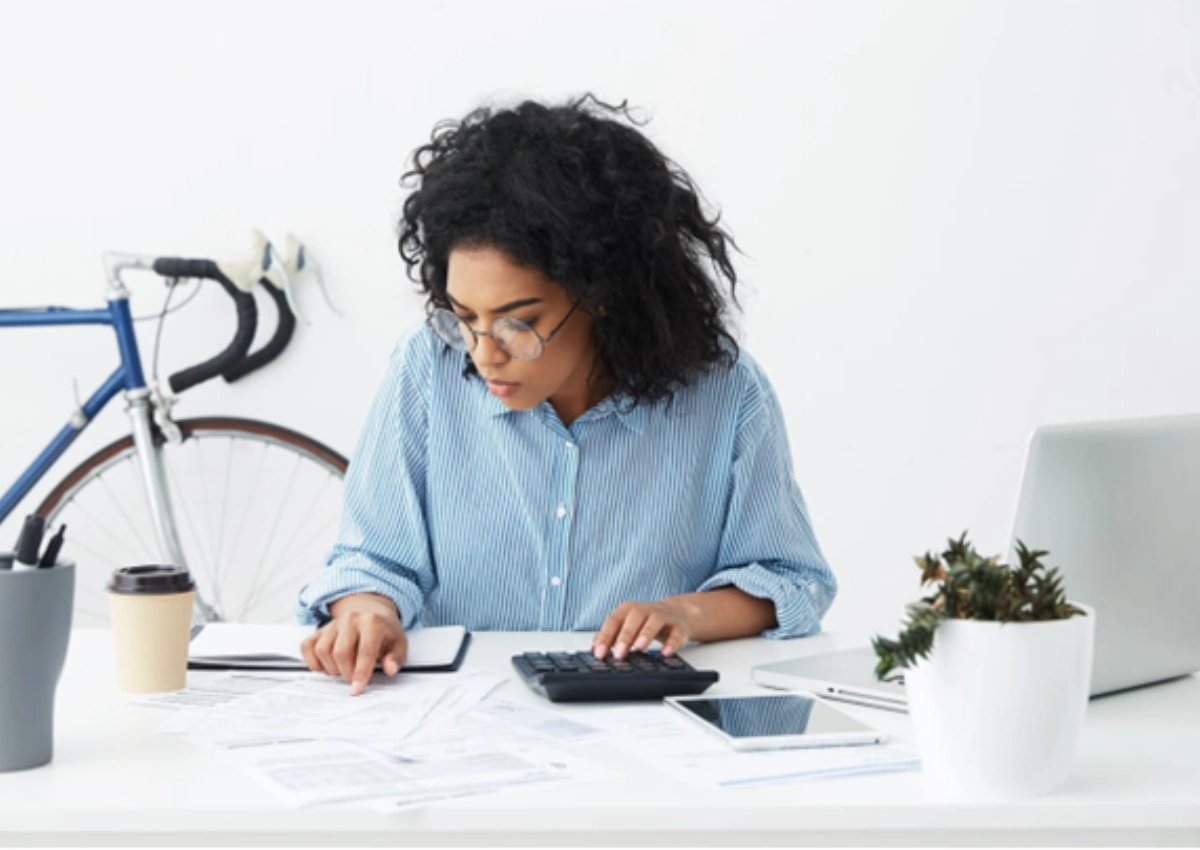 Mulher negra em mesa de escritório verificando como funciona a liquidação antecipada no BV.
