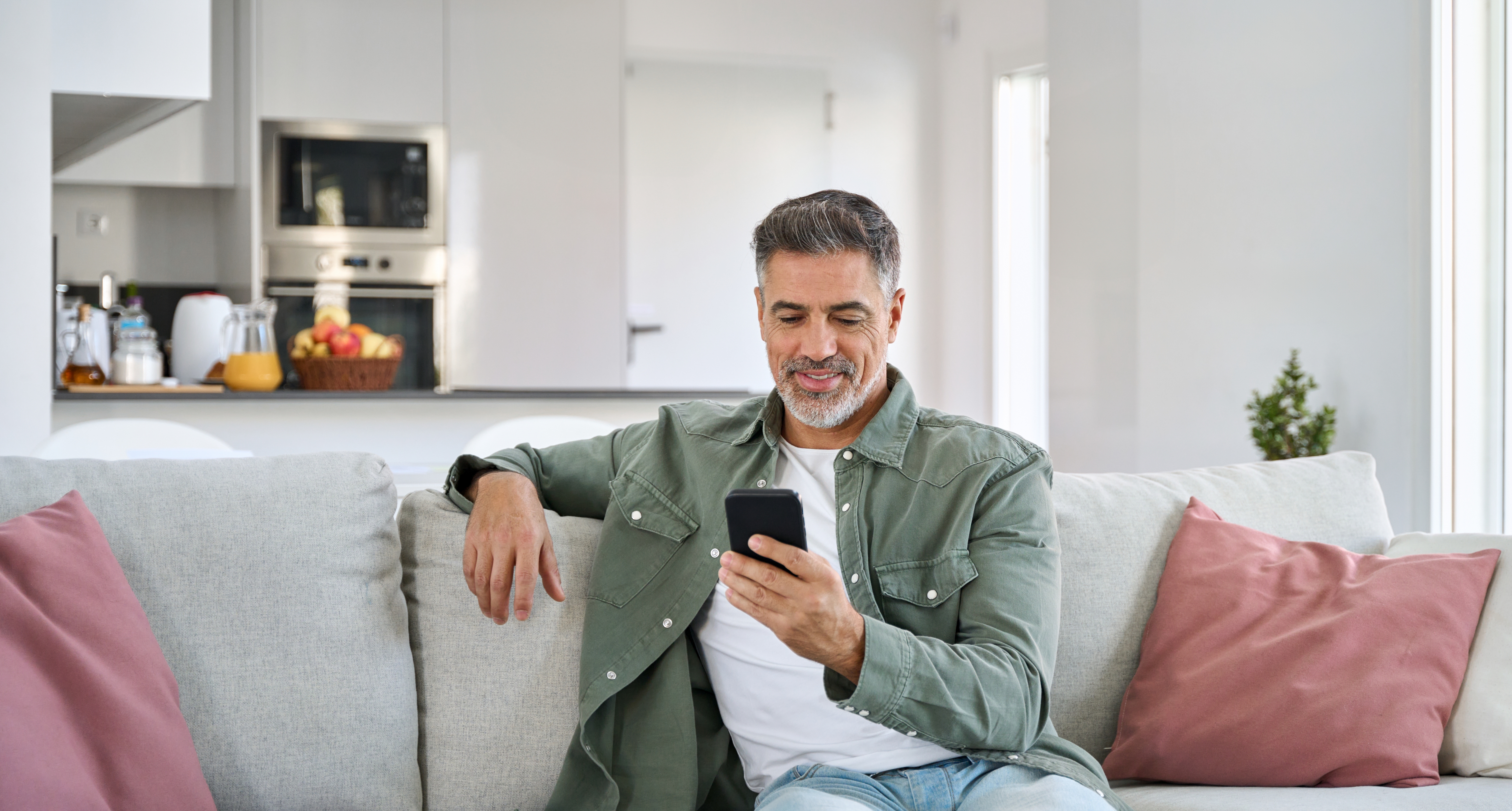 homem sentado no sofá mexendo no celular