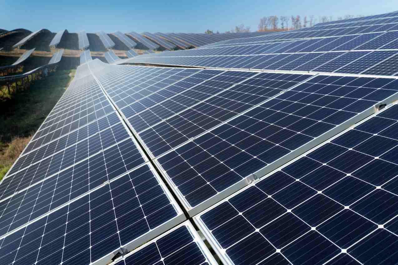 Painéis solares dispostos lado a lado em um campo aberto.