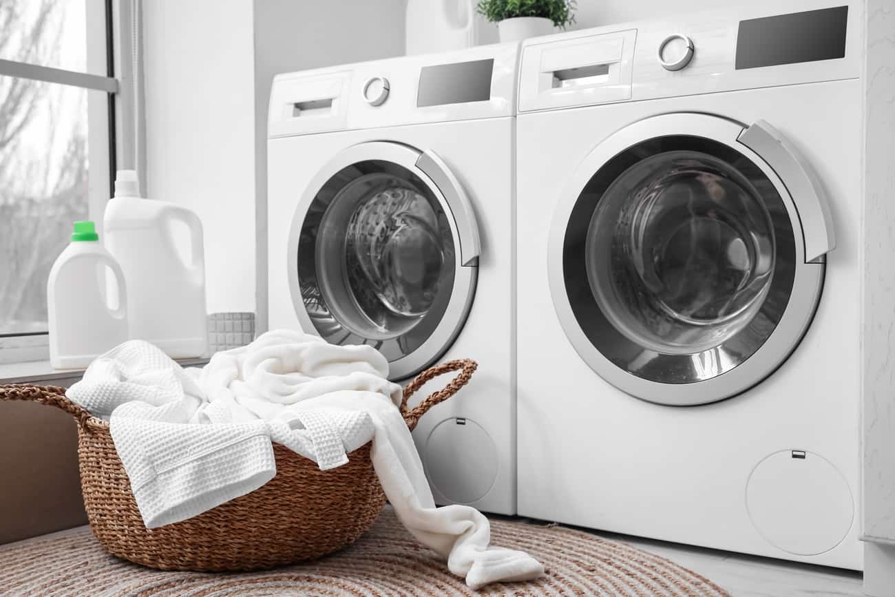 Duas máquinas lava e seca no ambiente de uma lavanderia.