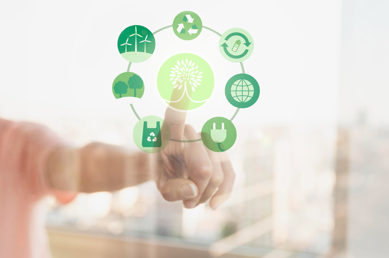 Pessoa tocando uma tela digital com ícones relacionados à sustentabilidade e energia limpa.