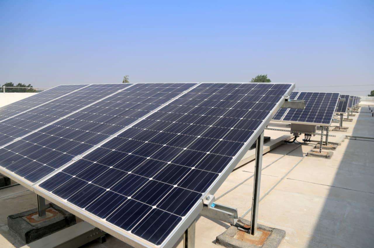 Placas solares instaladas em telhado sob céu limpo.