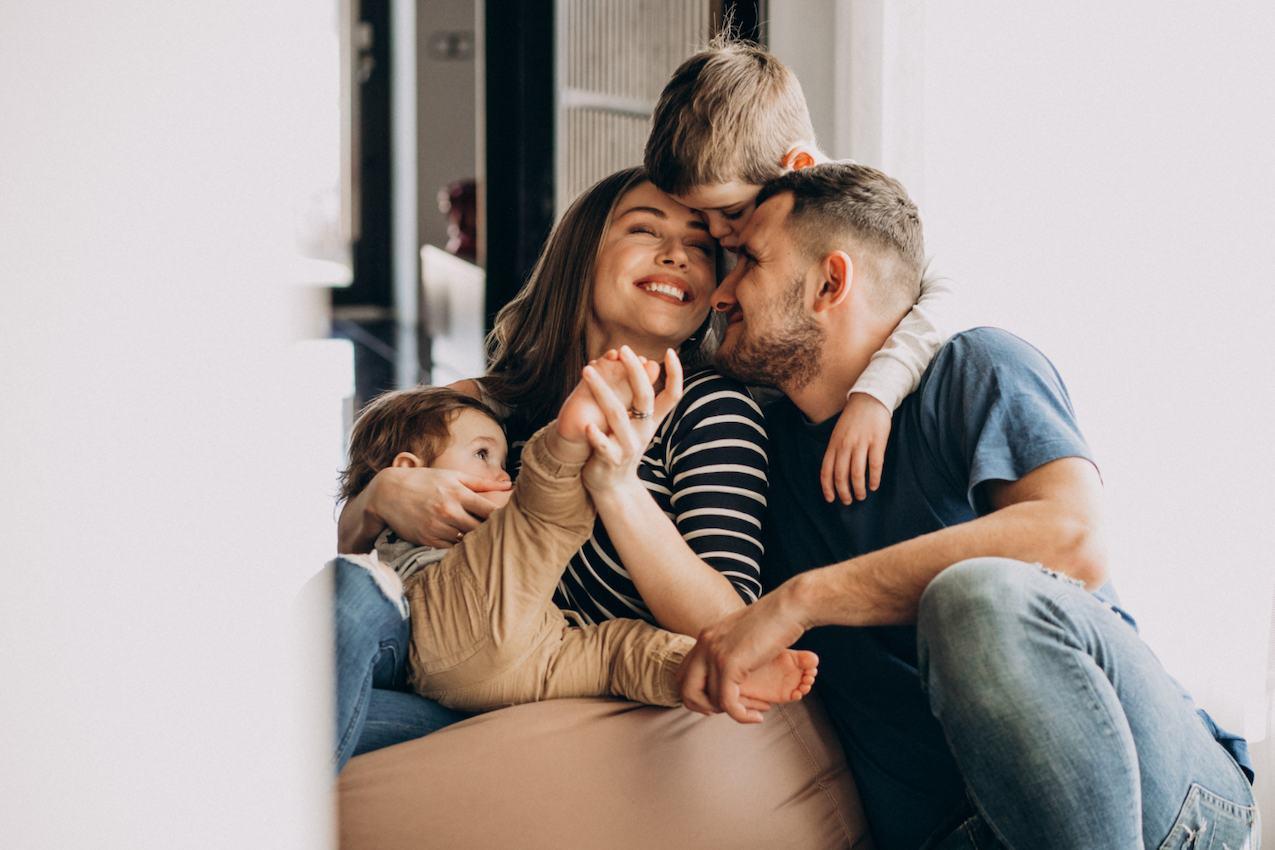 Família feliz se abraçando, simbolizando os benefícios de uma vida mais sustentável e econômica com a energia solar por assinatura.