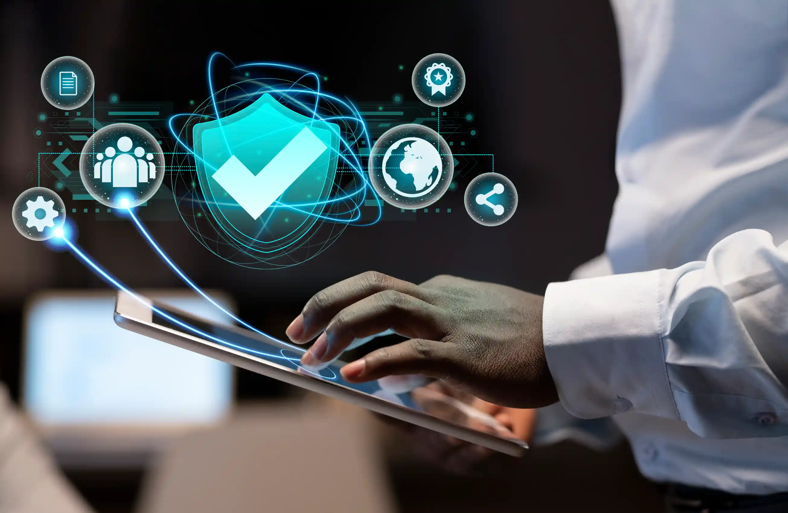 Uma mão usando um tablet; alguns ícones relacionados a segurança, dados e internet estão acima do dispositivo.​