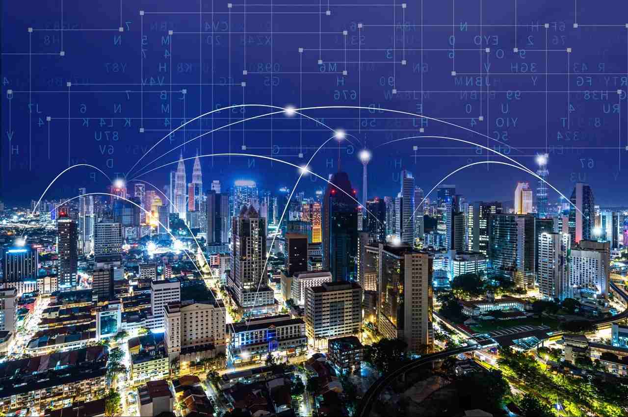 Smart City conecta prédios e cidade iluminada por luzes e linhas holográficas.