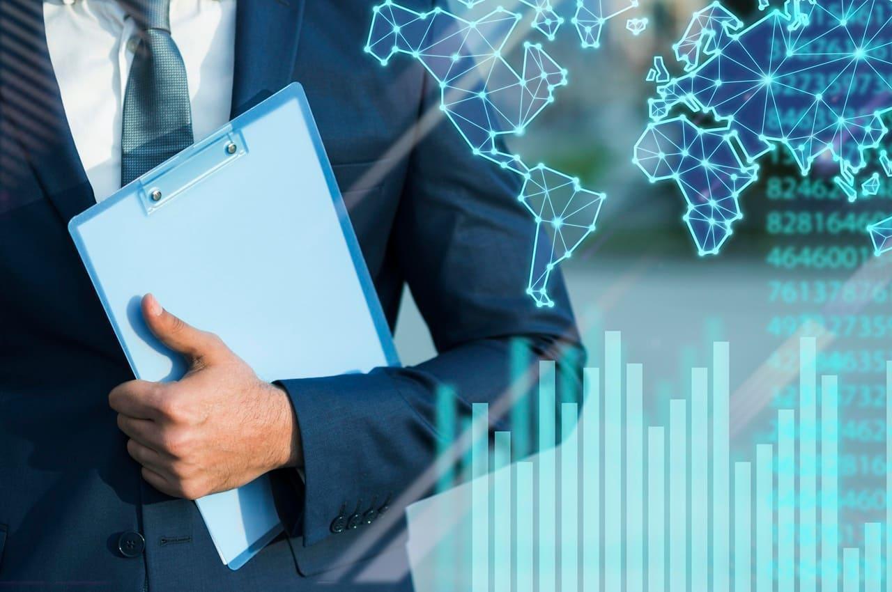 Pessoa de terno segurando uma prancheta. Ao fundo, há gráficos e mapas digitais, simbolizando operações de trade finance.
