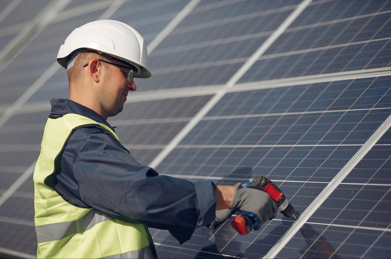 Técnico instalando painéis solares em telhado.