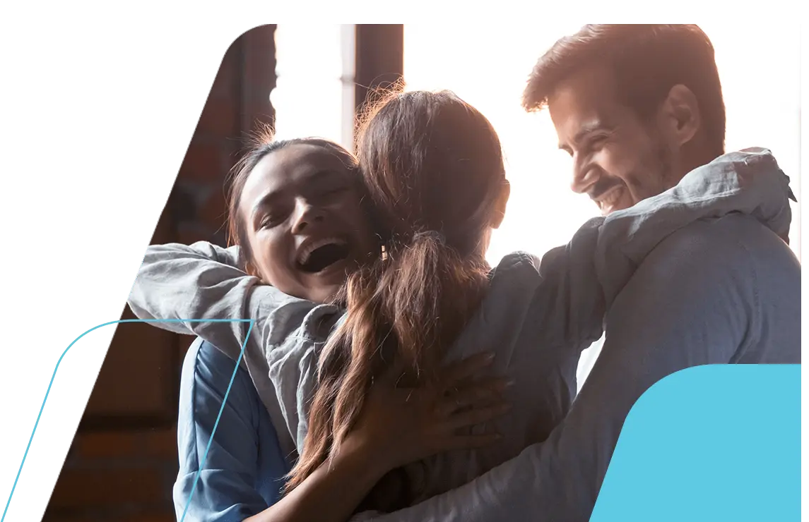 Família com pai e mãe sorrindo e abraçando a filha