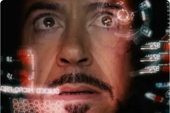 Imagem do rosto do ator Robert Downey Jr., que interpreta o personagem Homem de Ferro da Marvel, de dentro da armação de ferro. Ele está com uma feição preocupada.