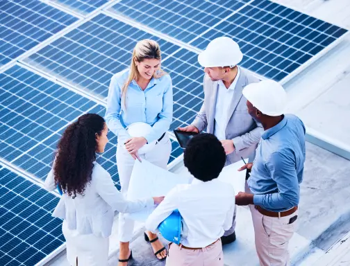 Dois homens e três mulheres reunidos conversando. Em suas mão eles seguram um projeto de instalação de placas solares.